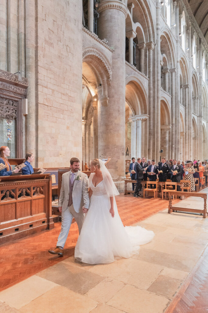 Bride and groom walk to the high altar in Romsey Abbey