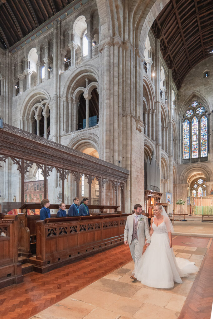 Bride and groom walk down the aisle in Romsey Abbey